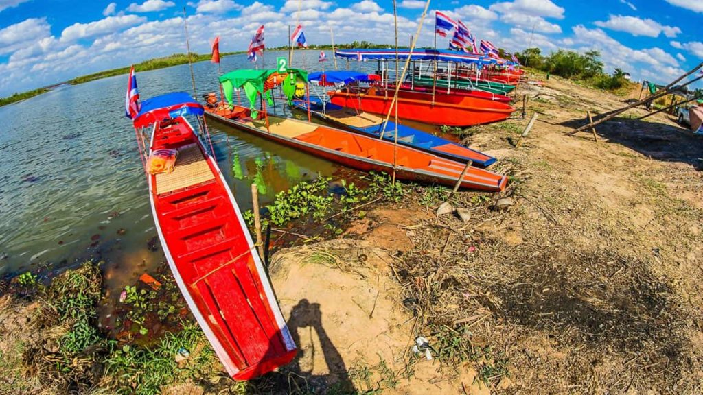 Boats among red lotus flowers at Red Lotus Lake