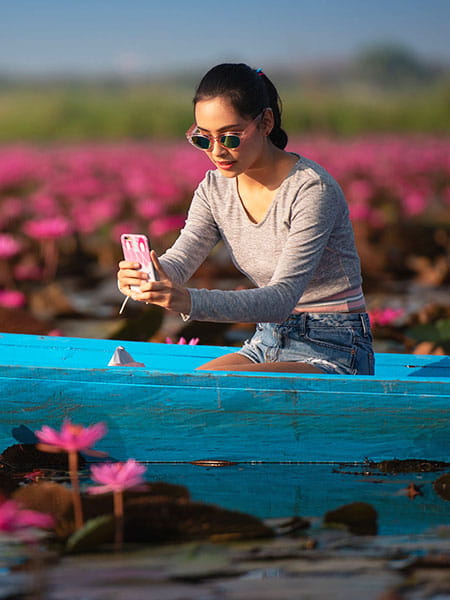 Young woman sitting in a blue canoe at Red Lotus Lake
