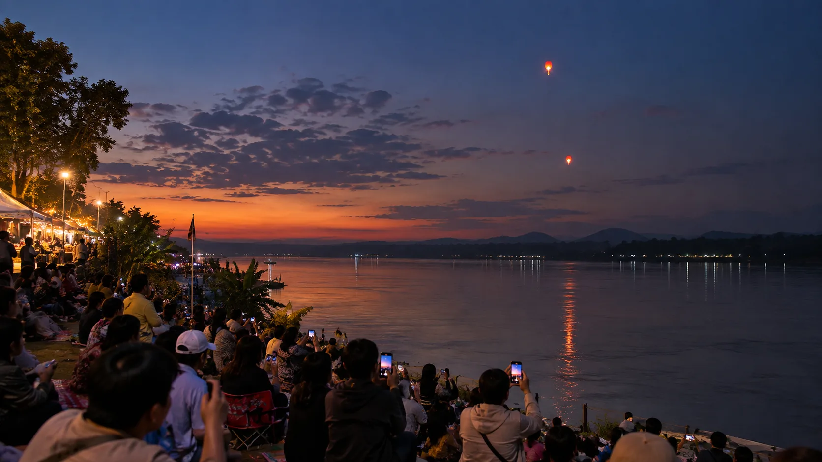 Crowds watching glowing red lights above the Mekong during a Naga Fireball Festival evening in Nong Khai.