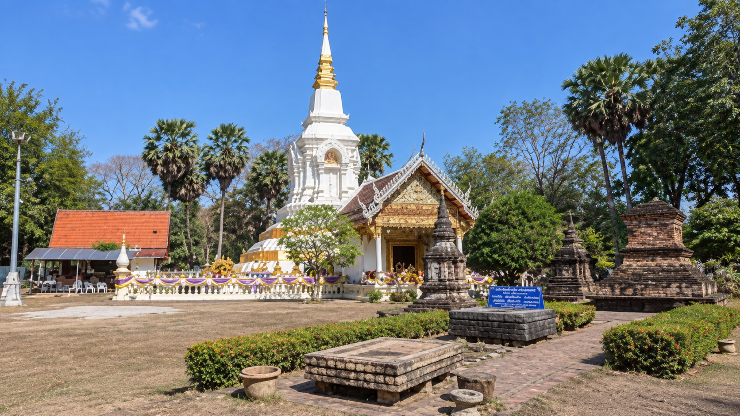 Wide view of Wat Phra That Bang Phuan showing the main stupa, temple hall and older sacred structures