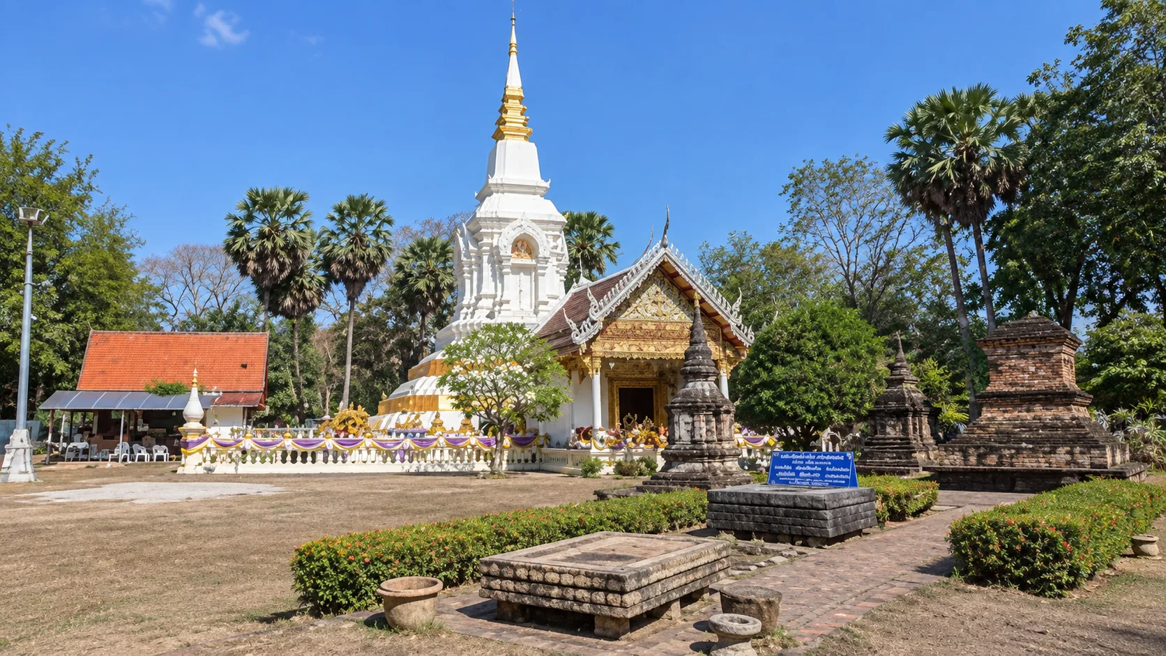 Wide view of Wat Phra That Bang Phuan showing the main stupa, temple hall and older sacred structures