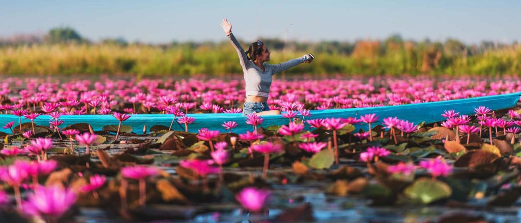 The Red Lotus Lake Thailand A Tourist Enjoying The Lake In A Blue Canoe