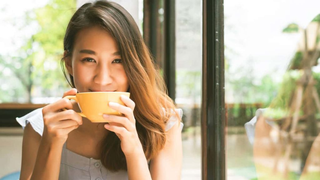 Cheerful Asian Young Woman Drinking Warm Coffee and Loving Life at Nakara Villas and Glamping