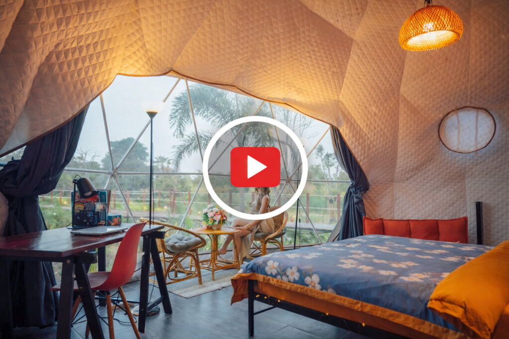 A beautiful woman looks out of a large 7m Dome at Nakara Villas and Glamping