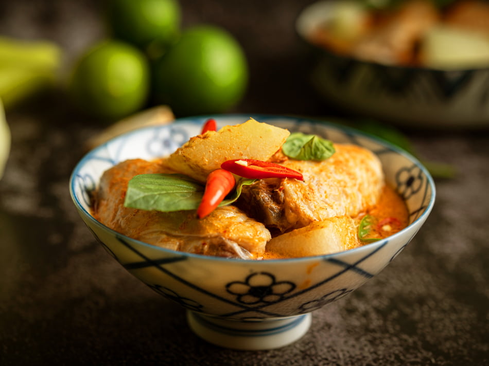 Massaman chicken curry with winter melon, basil and red chilli served in a traditional Thai bowl in Udon Thani
